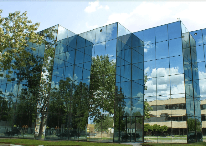 A building with many windows reflecting the sky.