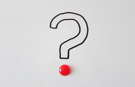 A question mark drawn on the wall with a red button.